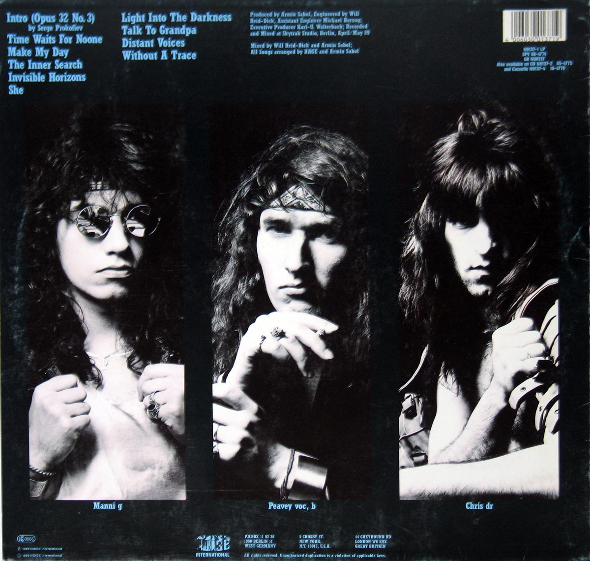 ‘Back cover of Rage’s Secrets in a Weird World album, featuring black-and-white portraits of the band members in individual panels. Manni (guitar) is on the left wearing sunglasses, Peavy (vocals, bass) is in the center with a bandana, and Chris (drums) is on the right with a shadowed, intense look. The tracklist is in the top left corner in light blue text, with production credits on the top right. The Noise Records logo and legal information are at the bottom.’